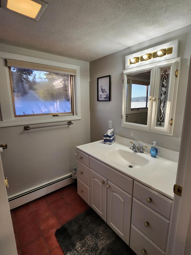 69 Scott Dr, Monmouth, ME 04259 - bathroom with a baseboard heating unit, vanity, tile patterned floors, plenty of natural light, and a textured ceiling