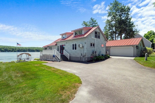 69 Scott Dr, Monmouth, ME 04259 - view of front of home with a metal roof, asphalt driveway, a front lawn, a water view, and a standing seam roof