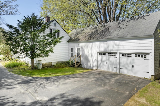 15 Winter St, Topsham, ME 04086 - view of side of home with driveway, a chimney, a shingled roof, and an attached garage