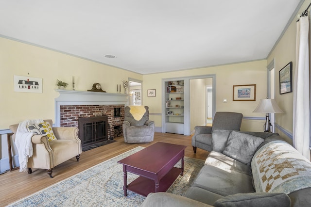 15 Winter St, Topsham, ME 04086 - living area featuring wood finished floors, built in features, and a brick fireplace