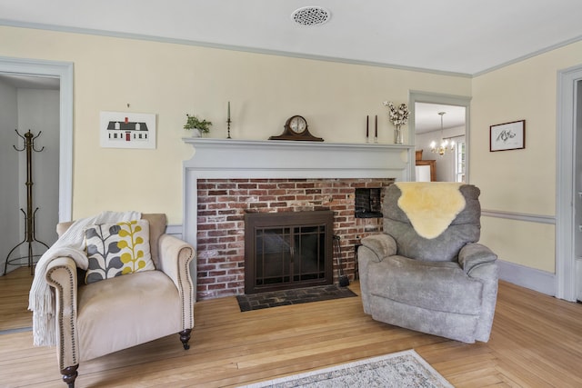 15 Winter St, Topsham, ME 04086 - living room featuring a fireplace, a chandelier, wood finished floors, and crown molding