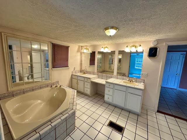1039 Belfast Rd, Knox, ME 04986 - bathroom featuring two vanities, a bath, tile patterned floors, and a textured ceiling