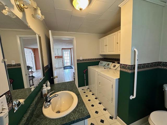 1039 Belfast Rd, Knox, ME 04986 - bathroom with washer and clothes dryer, vanity, crown molding, a wainscoted wall, and tile patterned floors