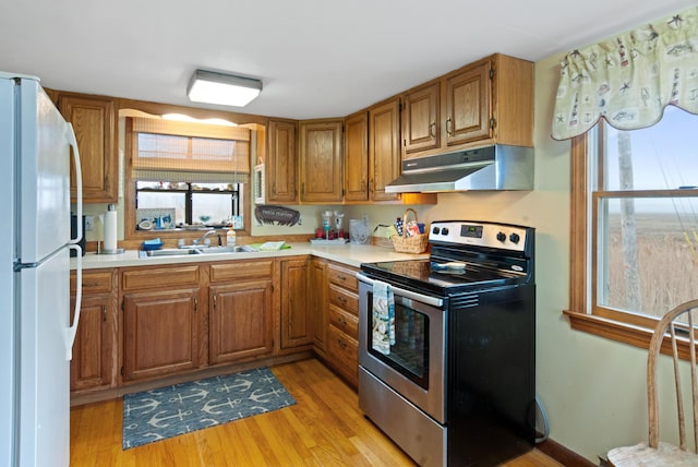428 Eldridge Rd, Wells, ME 04090 - kitchen with electric stove, under cabinet range hood, freestanding refrigerator, and light countertops