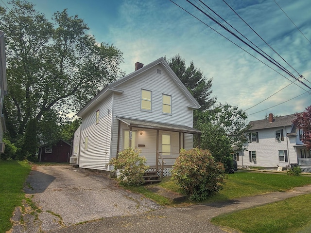 236 Birch St, Bangor, ME 04401 - view of front of home featuring covered porch, a chimney, a front lawn, and a storage shed