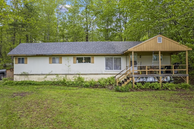 14 Lakeshore Dr, Belgrade, ME 04918 - view of front of house featuring covered porch, a shingled roof, and a front lawn