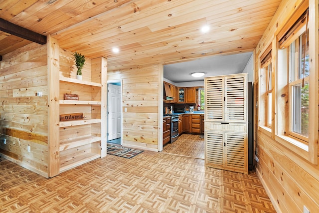11 Ridgewood Dr, Lebanon, ME 04027 - kitchen featuring gas stove, wooden walls, wood ceiling, brown cabinets, and custom range hood