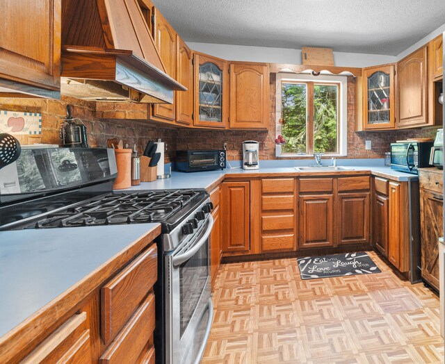 11 Ridgewood Dr, Lebanon, ME 04027 - kitchen featuring gas stove, custom range hood, light countertops, brown cabinets, and a textured ceiling