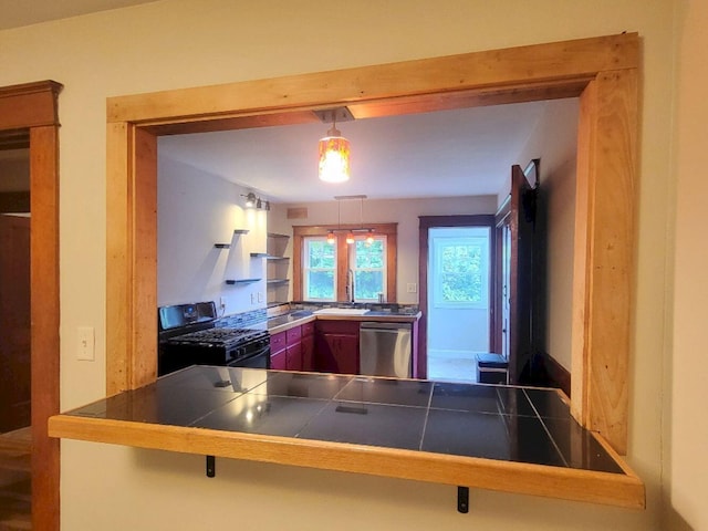 12 Allen St, Wilton, ME 04294 - kitchen with black gas range oven, stainless steel dishwasher, a peninsula, tile countertops, and a breakfast bar area