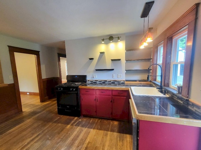 12 Allen St, Wilton, ME 04294 - kitchen with black gas range oven, wall chimney exhaust hood, red cabinetry, and dark wood-style floors
