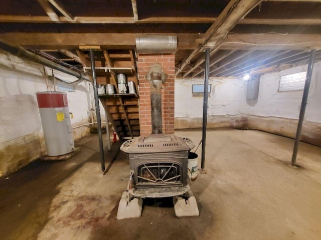 12 Allen St, Wilton, ME 04294 - unfinished below grade area featuring electric water heater and a wood stove