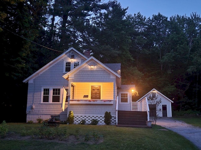 12 Allen St, Wilton, ME 04294 - view of front of property featuring an outdoor structure, a front lawn, concrete driveway, and a garage