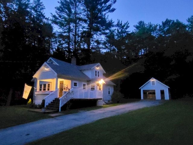 12 Allen St, Wilton, ME 04294 - view of front facade with an outdoor structure, a garage, a chimney, and a front yard