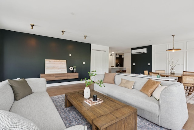 218 Washington Ave Unit 107, Portland, ME 04101 - living room featuring wood finished floors and a wall unit AC