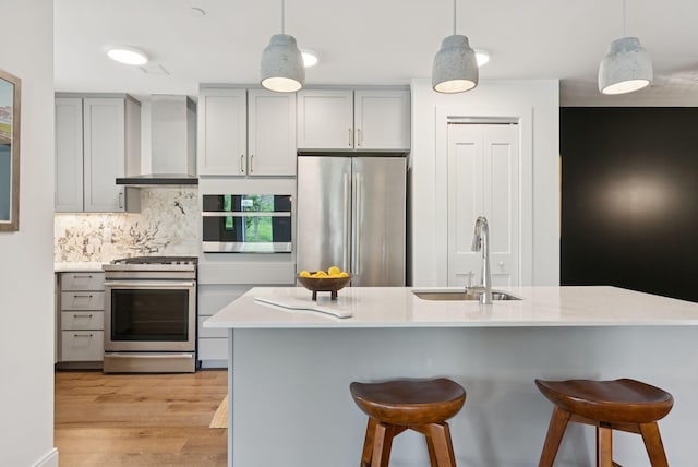 218 Washington Ave Unit 107, Portland, ME 04101 - kitchen with stainless steel appliances, wall chimney range hood, gray cabinets, and a breakfast bar