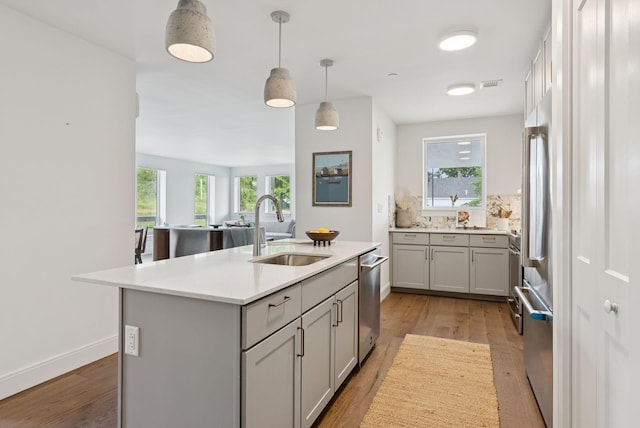 218 Washington Ave Unit 107, Portland, ME 04101 - kitchen with gray cabinets, an island with sink, light wood-style floors, and light countertops