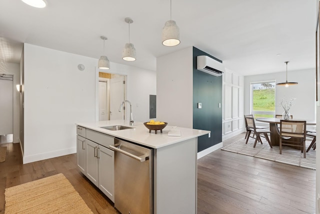 218 Washington Ave Unit 107, Portland, ME 04101 - kitchen with dishwasher, an AC wall unit, dark wood-type flooring, light countertops, and an island with sink