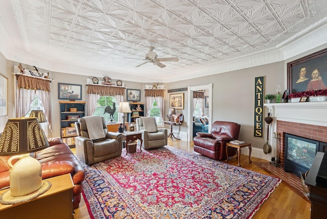709 High St, Bath, ME 04530 - living room with an ornate ceiling, a ceiling fan, a brick fireplace, wood finished floors, and crown molding