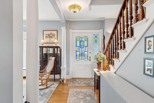 709 High St, Bath, ME 04530 - entrance foyer featuring light wood finished floors, ornamental molding, stairs, and decorative columns