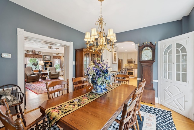 709 High St, Bath, ME 04530 - dining space featuring light wood-type flooring, a chandelier, arched walkways, and a ceiling fan