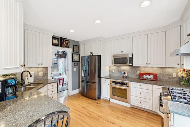 709 High St, Bath, ME 04530 - kitchen featuring stainless steel appliances, decorative backsplash, recessed lighting, light wood-style flooring, and white cabinetry