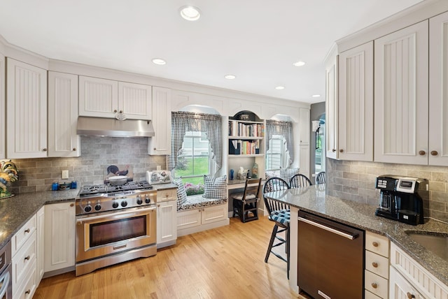 709 High St, Bath, ME 04530 - kitchen featuring stainless steel stove, dishwasher, under cabinet range hood, backsplash, and dark stone counters