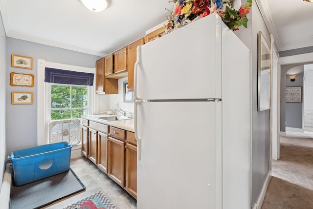 709 High St, Bath, ME 04530 - kitchen featuring freestanding refrigerator, crown molding, light countertops, brown cabinets, and arched walkways