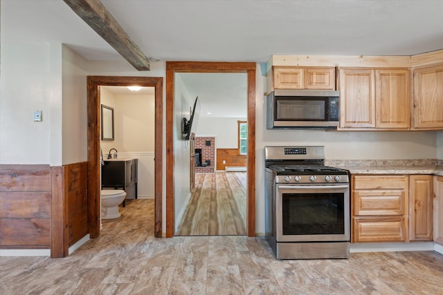 24 Blackswoods Rd, Franklin, ME 04634 - kitchen featuring appliances with stainless steel finishes, light brown cabinetry, light countertops, beam ceiling, and a fireplace