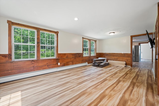 24 Blackswoods Rd, Franklin, ME 04634 - spare room featuring a wainscoted wall, a baseboard heating unit, wood walls, and wood finished floors