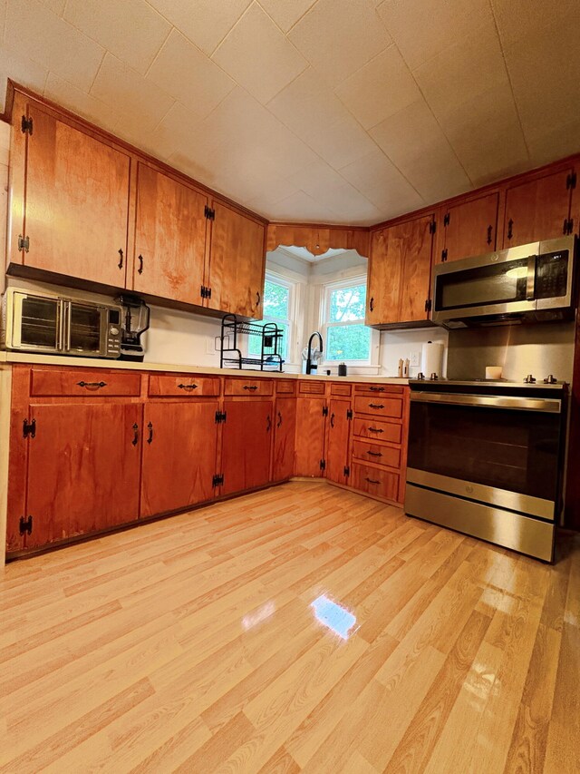 429 Rte 3, Palermo, ME 04354 - kitchen featuring appliances with stainless steel finishes, light wood-style flooring, and brown cabinetry