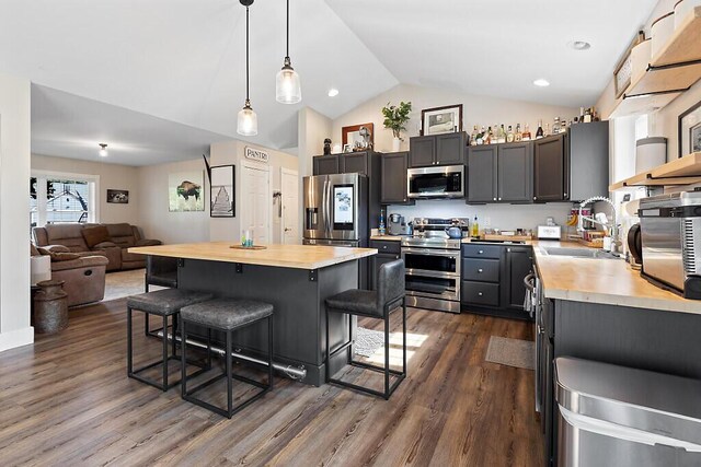 15 Fieldstone Dr, Augusta, ME 04330 - kitchen with appliances with stainless steel finishes, a breakfast bar area, wooden counters, lofted ceiling, and open floor plan