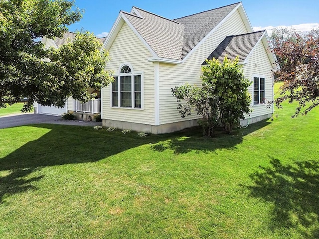 15 Fieldstone Dr, Augusta, ME 04330 - view of side of home featuring roof with shingles, a lawn, and a garage