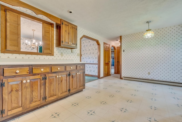 14 Pinewood Cir, Biddeford, ME 04005 - kitchen featuring wallpapered walls, baseboard heating, brown cabinets, pendant lighting, and a chandelier