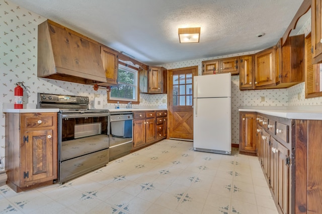 14 Pinewood Cir, Biddeford, ME 04005 - kitchen with freestanding refrigerator, electric stove, wallpapered walls, brown cabinetry, and a textured ceiling