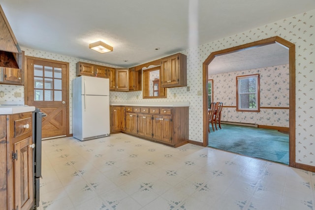 14 Pinewood Cir, Biddeford, ME 04005 - kitchen with freestanding refrigerator, wallpapered walls, a baseboard heating unit, light countertops, and brown cabinetry