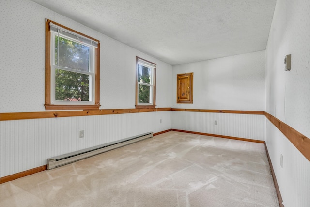 14 Pinewood Cir, Biddeford, ME 04005 - carpeted empty room featuring baseboard heating, plenty of natural light, a textured ceiling, wainscoting, and wallpapered walls