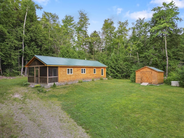 92 Cottage Shore Dr, Holden, ME 04429 - exterior space featuring a sunroom, a storage shed, a lawn, and a metal roof
