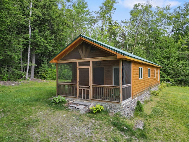 92 Cottage Shore Dr, Holden, ME 04429 - view of front of home with faux log siding, a sunroom, a front lawn, and a view of trees