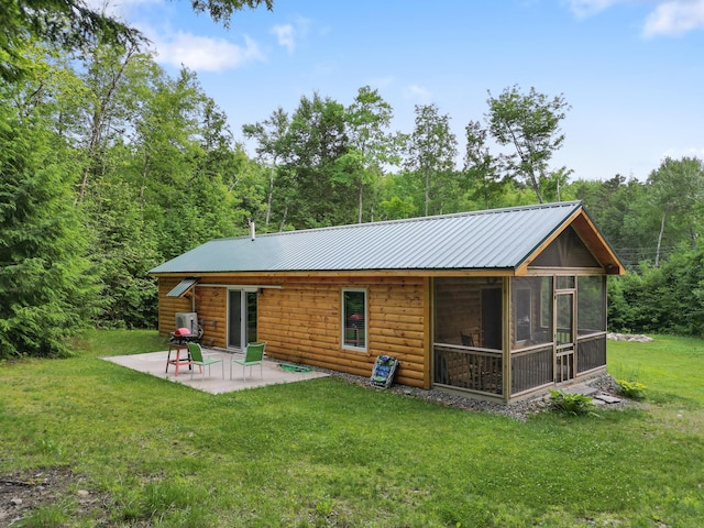 92 Cottage Shore Dr, Holden, ME 04429 - back of property with a patio area, a sunroom, a yard, faux log siding, and a wooded view