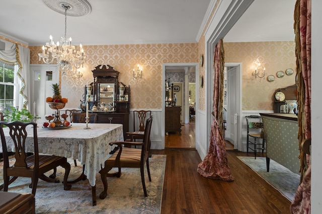 18 High St, Wiscasset, ME 04578 - dining space featuring wallpapered walls, wood-type flooring, wainscoting, a chandelier, and crown molding