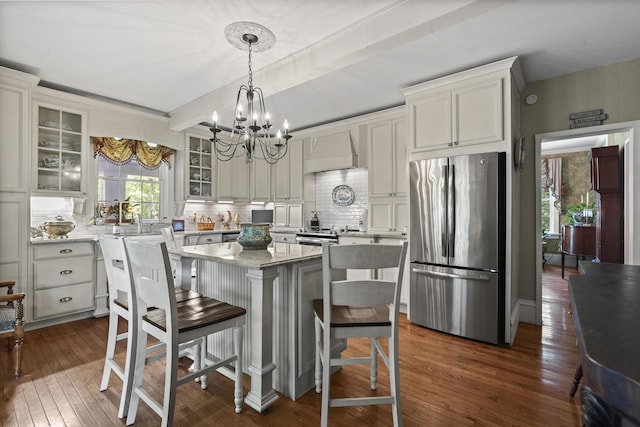 18 High St, Wiscasset, ME 04578 - kitchen featuring freestanding refrigerator, custom exhaust hood, a chandelier, dark wood finished floors, and tasteful backsplash