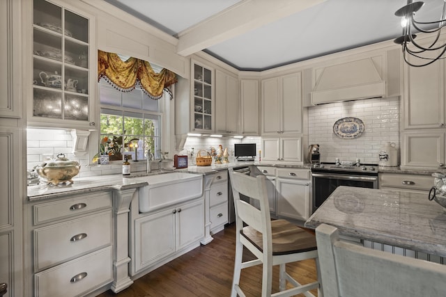 18 High St, Wiscasset, ME 04578 - kitchen featuring appliances with stainless steel finishes, tasteful backsplash, light stone countertops, dark wood finished floors, and glass insert cabinets