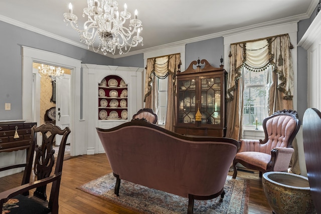 18 High St, Wiscasset, ME 04578 - sitting room with a chandelier, wood finished floors, crown molding, and built in shelves