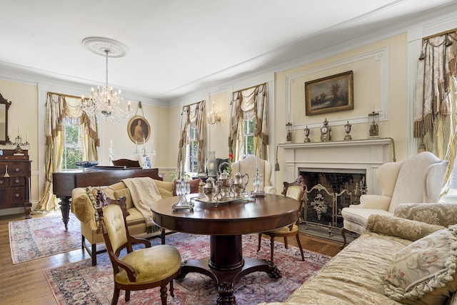 18 High St, Wiscasset, ME 04578 - sitting room with ornamental molding, a chandelier, wood finished floors, and a fireplace with flush hearth