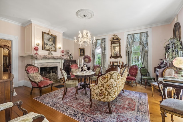 18 High St, Wiscasset, ME 04578 - living room with crown molding, light wood finished floors, a chandelier, and a fireplace