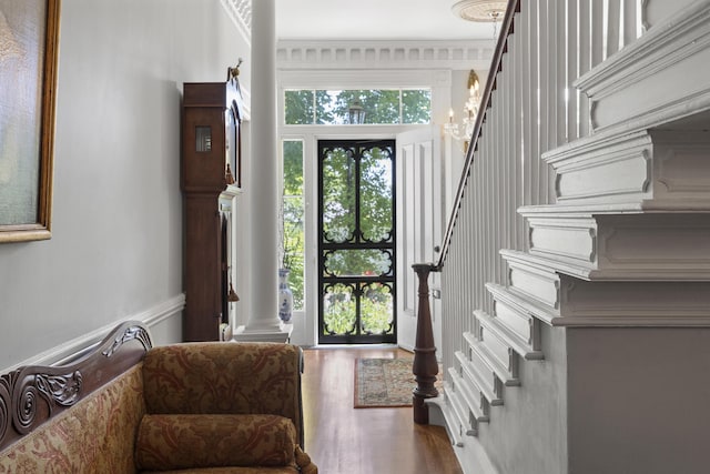 18 High St, Wiscasset, ME 04578 - entrance foyer featuring stairway, wood finished floors, decorative columns, and wainscoting