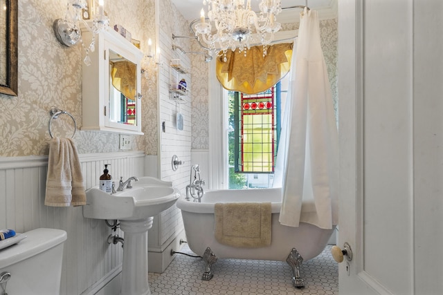 18 High St, Wiscasset, ME 04578 - full bath with wallpapered walls, a wainscoted wall, a freestanding tub, and a chandelier