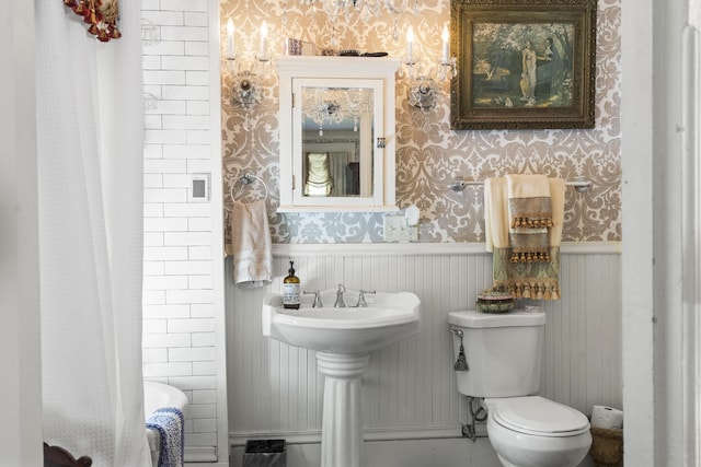 18 High St, Wiscasset, ME 04578 - bathroom with wallpapered walls, wainscoting, and shower / bath combo with shower curtain