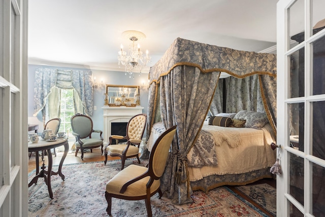 18 High St, Wiscasset, ME 04578 - bedroom featuring crown molding, a chandelier, wood finished floors, and a fireplace