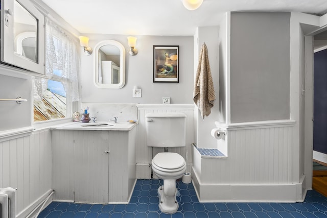 141 Centre St, Bath, ME 04530 - bathroom with vanity, wainscoting, radiator, and tile patterned floors